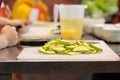 Cooking a dish in a culinary studio. Sliced vegetables on a cutting board and sauce in a measuring cup. Selective focus.