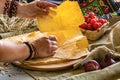 Brown hands in bracelets hold pita bread.Near tomatoes and onions. Horizontal