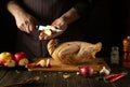 Cooking duck for lunch by the cook hands. Raw duck with apples and spices on the kitchen table. The chef cuts an apple Royalty Free Stock Photo