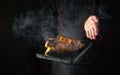 Cooking duck in the oven on a baking sheet. The chef introduces roasted hot poultry for a delicious lunch