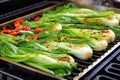 cooking exotic veggies like bok choy in a grill wok Royalty Free Stock Photo