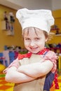 Cooking fever. Humorous portrait of cute child girl chef.