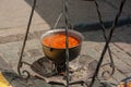 Cooking in field conditions. Boiling pot with soup hanging over the campfire Royalty Free Stock Photo