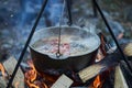 Cooking fish soup in the stowed bowler over a campfire. Royalty Free Stock Photo