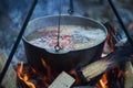 Cooking fish soup in the stowed bowler over a campfire. Royalty Free Stock Photo