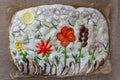 Cooking Focaccia. Raw focaccia creatively decorated with vegetables on parchment paper. Sourdough dough