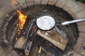 Cooking a foil covered pan of popcorn on fire pit