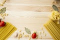 Cooking food background with free space for text. Composition with pasta, tomato, eggs, garlic, bay leaf over the wood background