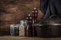 Cooking food background: rustic wood kitchen table, cast iron pan, spice grinders, cutting board, spices and seasonings, storage Royalty Free Stock Photo