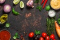 Cooking food composition. Frame made of fresh vegetables, spices, herbs and sauces on black stone background. Top view Royalty Free Stock Photo