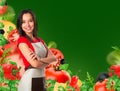 Cooking and food concept - smiling female chef, cook or baker with fork showing crossed arms sign over falling vegetables on green Royalty Free Stock Photo