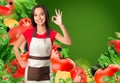 Cooking and food concept - smiling female chef, cook or baker with fork showing ok sign over falling vegetables on green Royalty Free Stock Photo