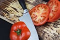 Cooking, food and home concept - close up cutting tomato on cutting board On Dark Background. Sliced tomatoes and knife with