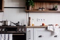 Cooking food on modern kitchen with steel oven, pots, knife on wooden cutting board with vegetables, pepper, spices,oil on wooden Royalty Free Stock Photo