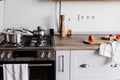 Cooking food on modern kitchen with steel oven, pots, knife on wooden cutting board with vegetables, pepper, spices,oil on wooden Royalty Free Stock Photo