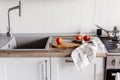 Cooking food on modern kitchen with steel oven, pots, knife on wooden cutting board with vegetables, spices on wooden tabletop at Royalty Free Stock Photo