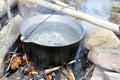 Cooking food with old tourist pot at outdoor fire place. Summer Royalty Free Stock Photo