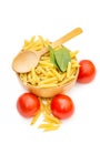 Cooking food. Wooden bowl with raw pasta, spinach, tomatoes and wooden spoon on white