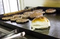 Cooking and Fraying Burgers and Hamburgers on Grill with Bread Loaf.