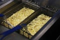 Cooking french fries. Close up of Frying french fries in the fryer in hot oil Royalty Free Stock Photo