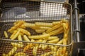 Cooking French fries in a hot fryer in hot oil. Royalty Free Stock Photo