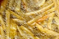 Cooking french fries in oil close-up, background. Potato frying with bubble