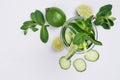 Cooking fresh summer organic lemonade with slices cucumber, ice, lime, mint, straw on white wood background, top view, closeup.