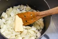 Cooking freshly chopped onion with butter to saute in a saucepan