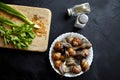 Cooking garden snails. Wooden cutting board and ingredients. Fresh mint leaves, green scallion, pepper, salt cellar and live