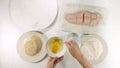 Fresh raw sea bass fillet and some ingredients, as flour, eggs, and and bread crumbs close up on a kitchen table on white backgrou Royalty Free Stock Photo