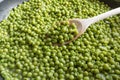 Cooking green peas in black frying pan with wooden spoon Royalty Free Stock Photo