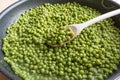 Cooking green peas in black frying pan with wooden spoon Royalty Free Stock Photo