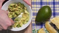 Cooking guacamole from raw avocado, stop motion timelapse, view from above. Vegetarian snack recipe made from natural