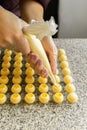 Cooking handmade chocolates. A confectioner pours liquid white chocolate into molds. Close-up. Selective focus. Royalty Free Stock Photo