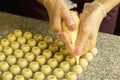 Cooking handmade chocolates. A confectioner pours liquid white chocolate into molds. Close-up. Selective focus. Royalty Free Stock Photo