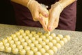 Cooking handmade chocolates. A confectioner pours liquid white chocolate into molds. Close-up. Selective focus. Royalty Free Stock Photo