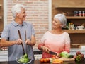 Cooking, health and happy of old couple in kitchen for salad, love and nutrition. Helping, smile and retirement with Royalty Free Stock Photo