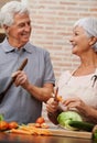 Cooking, health and lunch with old couple in kitchen for salad, love and nutrition. Happy, smile and retirement with Royalty Free Stock Photo