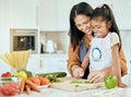 Cooking, health and mother and girl in kitchen for food, learning and salad together. Help, support and smile with mom Royalty Free Stock Photo