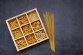 Cooking, healthy food concept. Different types of pasta in a wooden box on a dark background. View from above Royalty Free Stock Photo