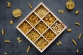 Cooking, healthy food concept. Different types of pasta in a wooden box on a dark background. View from above Royalty Free Stock Photo