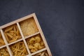 Cooking, healthy food concept. Different types of pasta in a wooden box on a dark background. View from above Royalty Free Stock Photo