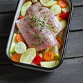 Cooking healthy food - raw ingredients: potatoes, zucchini, carrots, onions, garlic, peppers and fish sea bass in a baking dish Royalty Free Stock Photo