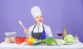 Cooking is her hobby. Cooking healthy food. Girl in hat and apron. Woman chef cooking healthy food. Fresh vegetables