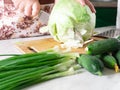 Cooking and home concept-close-up of a woman`s hands cutting cabbage on a cutting Board with a sharp knife. Royalty Free Stock Photo