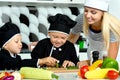 A family of cooks.Healthy eating. Happy family mother and children prepares vegetable salad in kitchen Royalty Free Stock Photo