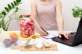 Cooking at home a woman watches online video recipes on a laptop and cooks in the kitchen at home Pickled pink cabbage Royalty Free Stock Photo