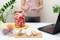 Cooking at home a woman watches online video recipes on a laptop and cooks in the kitchen at home writes in a notebook. Pickled Royalty Free Stock Photo