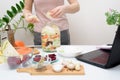 Cooking at home a woman watches online video recipes on a laptop and cooks in the kitchen at home Pickled pink cabbage Royalty Free Stock Photo