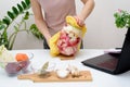 Cooking at home a woman watches online video recipes on a laptop and cooks in the kitchen at home Pickled pink cabbage Royalty Free Stock Photo